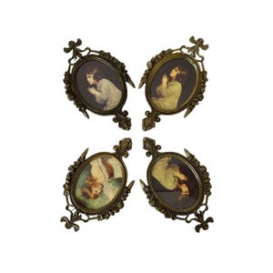 May include: Four antique oval picture frames with detailed bronze-colored filigree. Each frame holds a vintage print of a child in prayer. The frames are arranged in a square pattern against a white background.