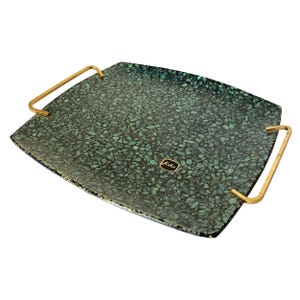 May include: A rectangular serving tray with a mosaic-like pattern in shades of teal and black. The tray has gold-colored handles on each side and a small label that reads "Koha".