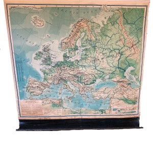 May include: A vintage map of Europe with a green and blue color scheme. The map shows the countries of Europe, including the United Kingdom, France, Germany, Italy, Spain, and Russia. The map also shows the major rivers and mountains of Europe. The map is titled "Europe" and is printed on a light brown background.
