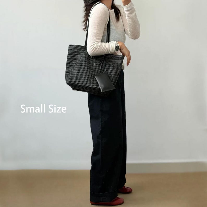 May include: Black woven tote bag with a matching small pouch. The bag has a rectangular shape with a structured design and long handles. The text "Small Size" is visible on the left side of the image.