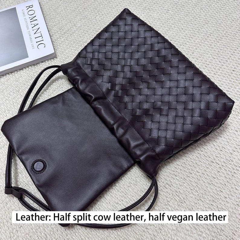 May include: A dark brown leather drawstring bag with a woven pattern. The bag is open, revealing a smooth, dark brown interior pouch with a button closure. The text "ROMANTIC" is visible on a book in the background. The bag is made of half split cow leather and half vegan leather.