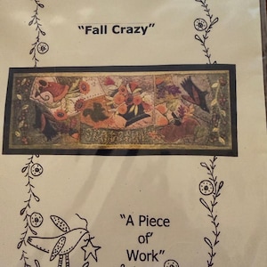 May include: A rectangular paper print featuring the text Fall Crazy and A Piece of Work. The design includes a central horizontal illustration of autumn-themed floral and bird motifs, surrounded by a hand-drawn vine border with small circular accents.