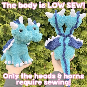 May include: Handmade turquoise and navy blue crochet dragon plushies. One dragon has two heads, and the other has one. The dragons have white horns and spines. The text on the image reads, "The body is LOW SEW! Only the heads & horns require sewing!"