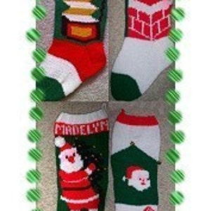 May include: Four knitted Christmas stockings with different designs. The stockings are white with green, red, and white accents. The stockings are decorated with Santa Claus, a candy cane, and a chimney. The stockings are personalized with the names "Renick", "Madelyn", and two other names.