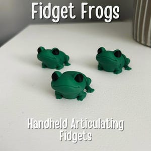 Può includere: Tre giocattoli fidget a forma di rana verde. Le rane hanno occhi neri e sono articolate alle gambe e alla testa. Fidgets articolati da tenere in mano.