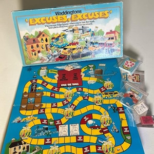 May include: A Waddingtons Excuses, Excuses board game set featuring a blue game board with a yellow path, cartoon illustrations, and a box lid displaying the game title and a chaotic traffic scene. Includes several small decks of game cards.