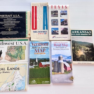 Peut inclure: Ensemble de cartes et de guides de voyage vintage, dont "Portrait U.S.A.", "Texas Official Travel Map" et "Arkansas 1975 State Highway M". Les cartes présentent des designs et des textes colorés, présentant diverses régions et attractions.