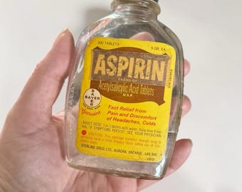 Frasco de vidrio antiguo de aspirina Bayer con etiqueta amarilla, decoración de boticario.