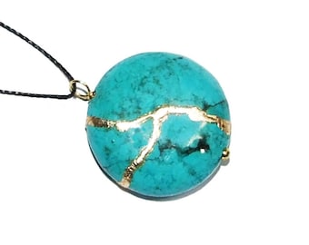May include: A turquoise pendant necklace with gold accents. The pendant is round and has a marbled pattern. The necklace is on a black cord.