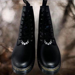 Może przedstawiać: Zestaw trzech ceramicznych kubków z nakrapianym, matowym wykończeniem. Kubki są w odcieniach kremu, jasnoszarym i ciemnoszarym. Każdy kubek ma prosty, minimalistyczny design i zaokrąglony uchwyt.