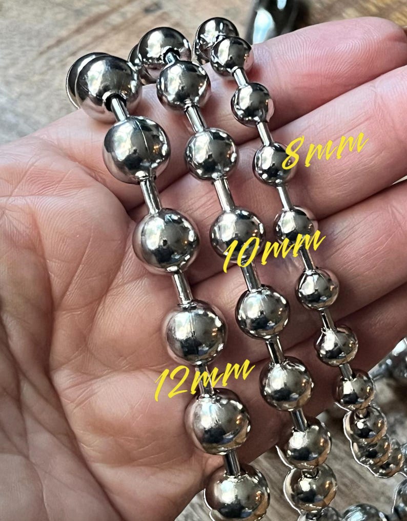 Op de afbeelding: Drie zilveren kogelkettingen met verschillende maten ballen. De kettingen zijn ge&euml;tiketteerd met 8 mm, 10 mm en 12 mm.
