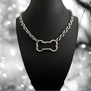 May include: A silver chain necklace with a bone-shaped pendant.