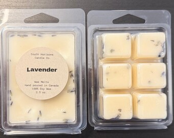 May include: Two clear plastic clamshells containing lavender-scented wax melts. One contains a solid block with a label that reads "Lavender" and "Wax Melts." The other contains six individual cubes. The wax is a pale yellow color with visible lavender pieces.