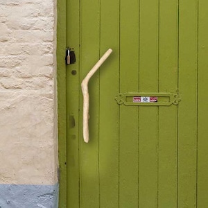 May include: A green wooden door with a unique wooden door handle. The door has a number "12" on the wall next to it.
