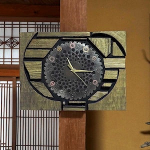 May include: A rectangular wall clock with a steampunk design. The clock face is a circular saw blade with gold hands and small gears. The clock is set in a wooden frame with a gold finish and is mounted on a wooden post.