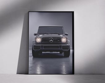 Puede incluir: Impresión enmarcada de un SUV negro, visto de frente. El vehículo tiene una parrilla delantera distintiva con el emblema de la marca y faros redondos encendidos. La imagen está sobre un fondo gris, con el reflejo del vehículo visible.