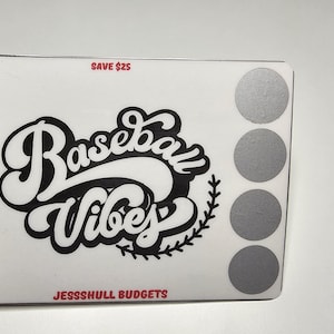 May include: White sticker with black text that reads "Baseball Vibes" in a stylized font. The sticker is on a white background with a row of silver circles on the right side. The text "Save $25" is at the top of the sticker and the text "JessShull Budgets" is at the bottom.