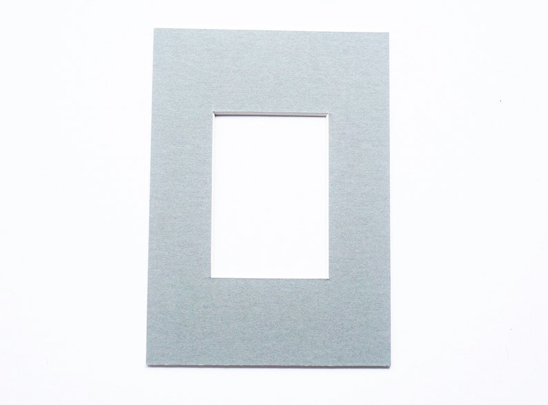 May include: A gray mat with a rectangular opening in the center. The mat is textured and has a subtle sheen.