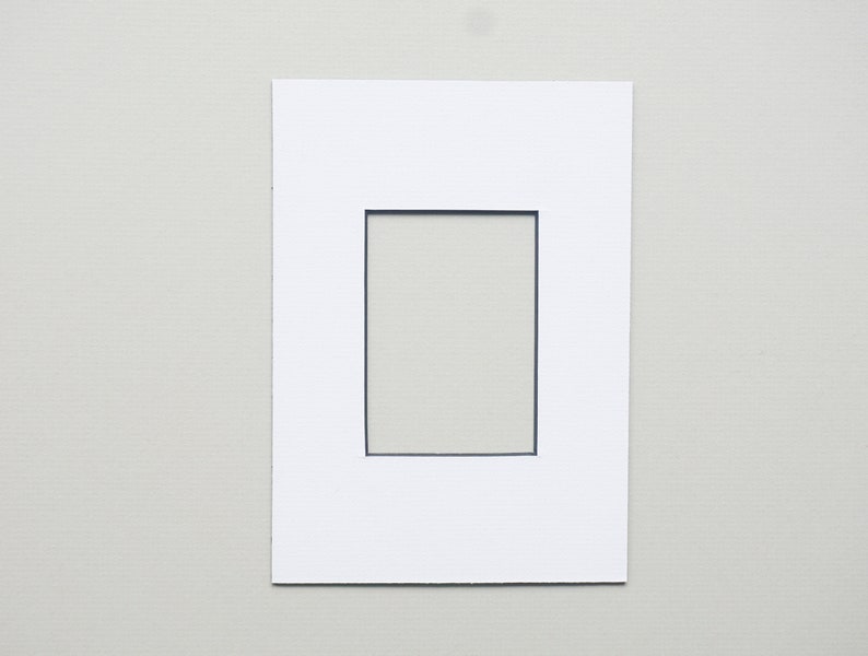 May include: White mat with a black rectangular opening in the center.