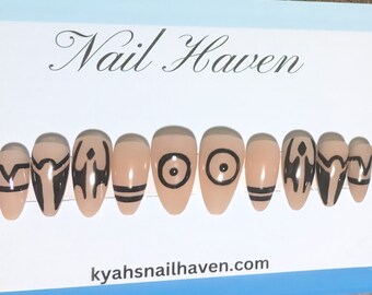May include: Set of ten nude-coloured false nails with black geometric designs. The designs include circles, triangles, and lines. The nails are arranged in a row on a white background with the text "Nail Haven" and "kyahsnailhaven.com".