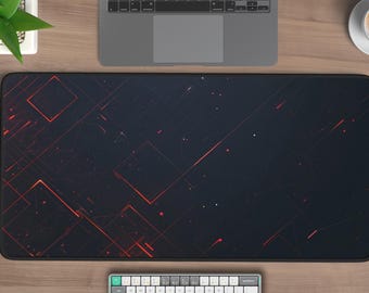May include: A large black and red rectangular desk mat with a geometric design. The mat features a dark background with red lines and shapes, and is surrounded by a keyboard, laptop, mouse, and a small plant.