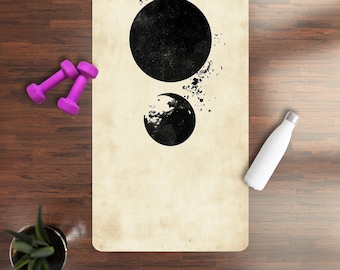 May include: A yoga mat with a vintage, cream-colored background and a black abstract design of three circles. The circles are different sizes and have a slightly textured look.