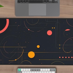May include: A black mouse pad with a geometric design featuring orange and red circles and lines on a dark background.