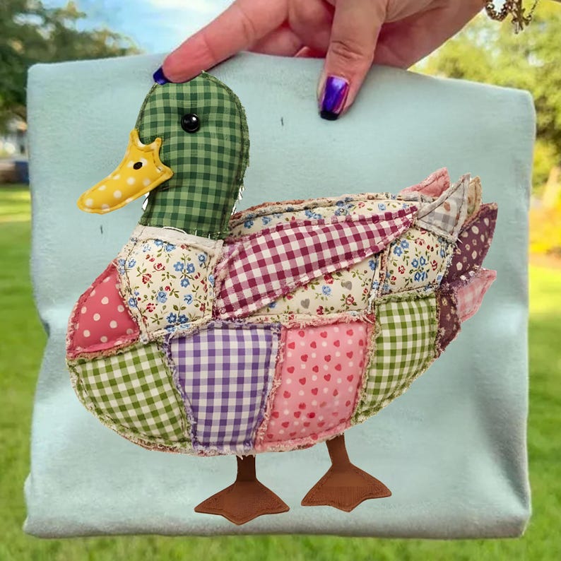 May include: A colorful patchwork duck with a green checkered head and a yellow beak. The duck's body is made of various patterned fabrics, including polka dots, floral prints, and gingham. Brown feet complete the design. The duck is held against a light blue background.