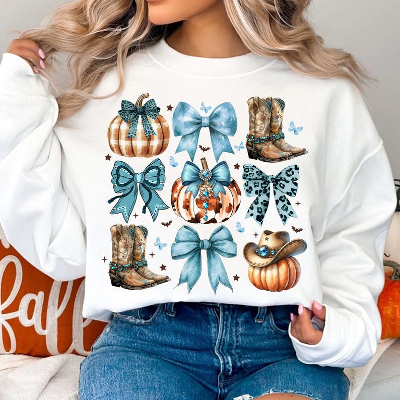 May include: White sweatshirt with a blue, brown, and white design featuring pumpkins, bows, cowboy boots, and a cowboy hat.