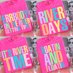 May include: Four bright pink t-shirts with colorful text. One shirt says "ERRBODY ON THE RIVER GETTING TIPSY." Another says "RIVER DAYS." The third says "IT'S RIVER TIME," and the fourth says "BOATIN AND FLOATIN."