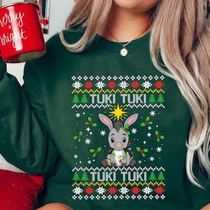 May include: Green Christmas sweater with a cartoon donkey wearing Christmas lights and the text "Tuki Tuki" repeated twice.