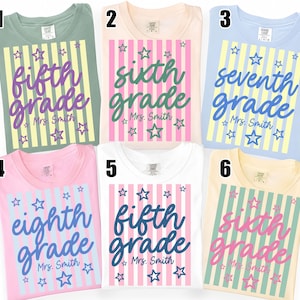 Könnte beinhalten: Sechs T-Shirts in verschiedenen Pastellfarben mit vertikalen Streifen und Sternmotiven. Jedes T-Shirt zeigt Text wie fifth grade, sixth grade, seventh grade oder eighth grade sowie den Namen Mrs. Smith in einer kursiven Schriftart.