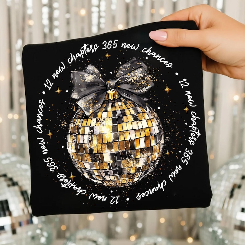 Pu&ograve; includere: Quadrato nero con un design a palla da discoteca dorata e nera, un fiocco nero e il testo "12 new chapters 365 new chances". Il design include stelle dorate e dettagli glitterati.