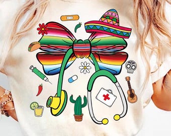 May include: White t-shirt with a colorful Mexican-style bow, a stethoscope, and other small details like a cactus, a taco, and a first aid kit.
