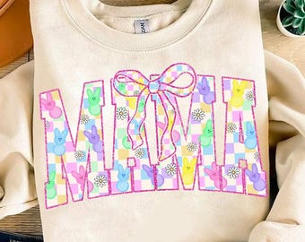 Può includere: Una felpa beige chiaro con la parola "MAMA" in lettere rosa bordate. Le lettere sono riempite con un motivo a scacchi rosa pastello, blu, giallo e verde. Ci sono piccoli fiori bianchi e forme di coniglietti pastello in tutto il motivo. Un fiocco rosa con un motivo a scacchi bianchi è centrato sopra la parola "MAMA".