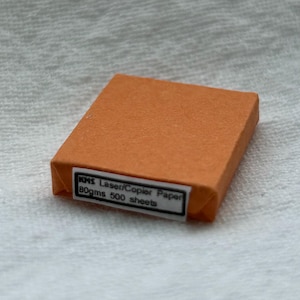 May include: A rectangular orange box of KMS Laser/Copier Paper, 80gms 500 sheets.