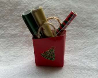 Bolsa navideña en miniatura con rollos de papel de regalo
