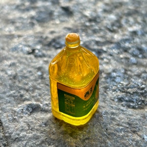 May include: A clear plastic bottle filled with yellow liquid. The bottle has a green label with Chinese text and a sunflower graphic.