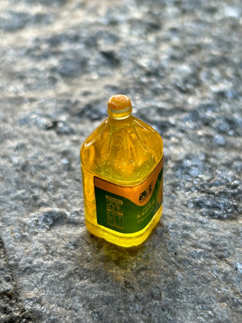 May include: A clear plastic bottle filled with yellow liquid. The bottle has a green label with Chinese text and a sunflower graphic.