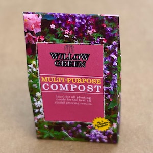 Puede incluir: Una bolsa rosa y morada de compost multiusos Willow Green. La bolsa tiene una etiqueta blanca con el texto "Willow Green Multi-Purpose Compost" y "Ideal para todas las necesidades de plantación para los mejores resultados de crecimiento en general." Una estrella amarilla con el texto "No. 1 For Garden Products" está en la esquina inferior derecha.