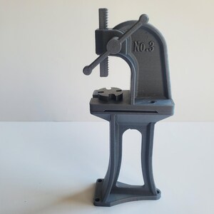 May include: A gray metal bench vise with a hand crank and a base. The vise is labeled "No. 3".