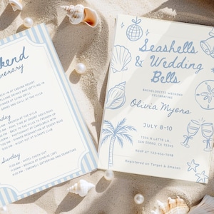 Peut inclure: Deux cartons d'invitation sur du sable avec des coquillages et des perles. L'un dit "Itin&eacute;raire du week-end" avec un programme. L'autre dit "Coquillages et cloches de mariage" avec les d&eacute;tails de l'&eacute;v&eacute;nement et le nom d'Olivia Myers.