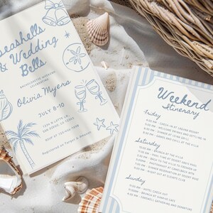 Peut inclure: Deux invitations avec du texte et des illustrations bleues sur fond cr&egrave;me. L'une dit "Seashells & Wedding Bells" et l'autre est un itin&eacute;raire de week-end. Des coquillages et un panier en osier sont en arri&egrave;re-plan.