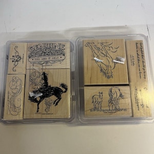 May include: A set of wooden rubber stamps in a clear plastic case. The stamps feature designs of horses, a bucking bronco, and text including "GENUINE THE ONE & ONLY" and "God forbid that I should go to any heaven in which there are no horses."