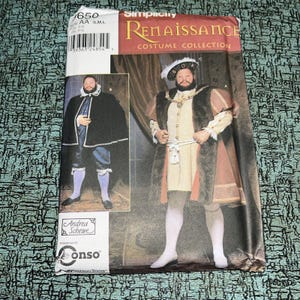 May include: A Simplicity Renaissance Costume Collection sewing pattern envelope, number 1650, featuring illustrations of two historical outfits. The package displays a man in a black cape and another in a tan and brown fur-trimmed doublet with a hat.