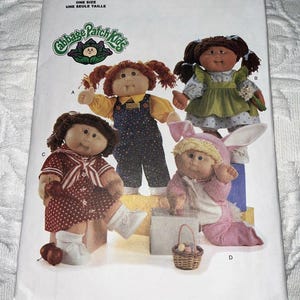 May include: A Butterick 5902 sewing pattern envelope for Cabbage Patch Kids dolls. The front features illustrations of four dolls in various outfits: overalls, a green dress, a red polka-dot dress, and a pink bunny costume with a small basket.