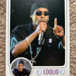 May include: Trading card featuring a portrait of Coolio, wearing sunglasses and a black beanie, holding a microphone. The card includes a smaller inset image and the text "Coolio Gangsta's Paradise".