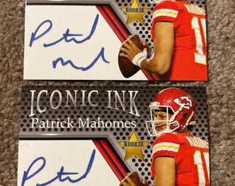 Puede incluir: Dos tarjetas coleccionables con Patrick Mahomes en uniforme de fútbol rojo. Las tarjetas tienen el texto "ICONIC INK" y "Patrick Mahomes" impresos, junto con una firma. Las tarjetas también tienen una estrella "ROOKIE".