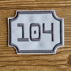 May include: A white ceramic mug with a black handle and the text "But First, Coffee" in a black, bold font. The mug is on a white surface.