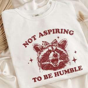 Camiseta de mapache feminista que no aspira a ser humilde, camiseta de mapache divertida que defienda al patriarcado, camiseta de furia femenina que defiende los derechos de las mujeres y aplasta el patriarcado